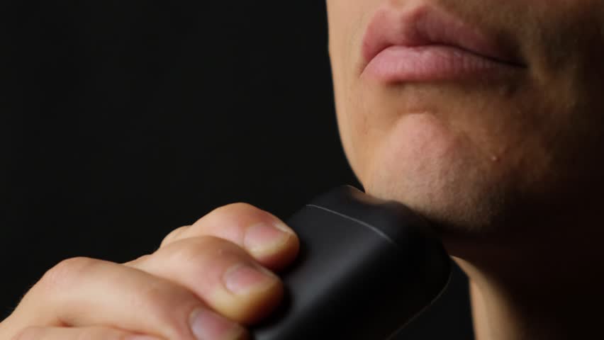 Modern electric shaver close up in use, compact grooming technology and innovation