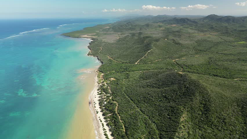 Cinematic 4K drone view of Popa Beach — gentle surf lines create patterns of gold and blue hues in shallow water. Ideal for tropical travel promos