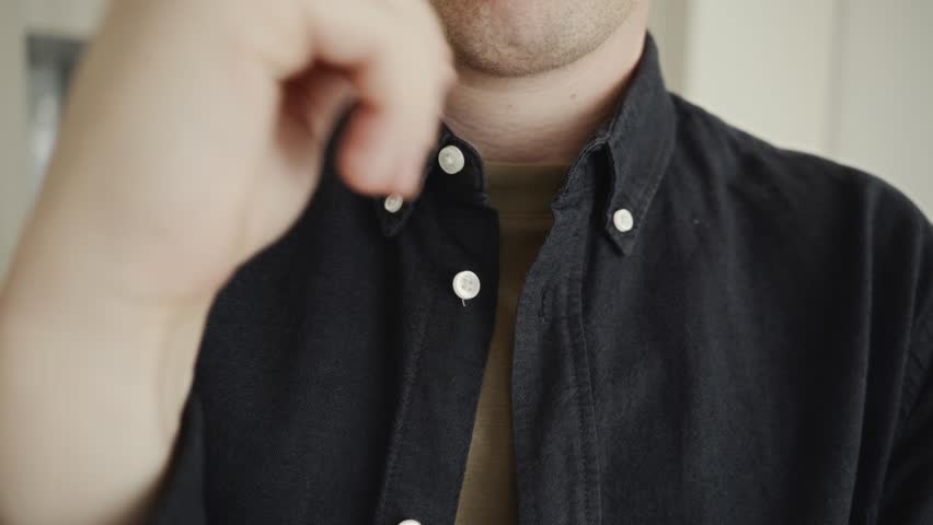Close-up of a man adjusting the sleeve of his shirt. Scene emphasizes minimalism, neat fashion, and daily simplicity in clothing style. High quality 4k footage