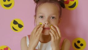 The person puts emoji stickers on their face. The use of emoticons for the convenience of communication and transmission of emotions in social media. World Smile Day - Powered by Shutterstock - Get 15% off with code: PIKWIZARD15