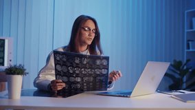 Neurology Consultation. Professional Female Doctor in White Coat Reviews Brain Scans During Evening Online Meeting, Providing Expert Analysis and Collaboration in Remote Medical Practice - Powered by Shutterstock - Get 15% off with code: PIKWIZARD15