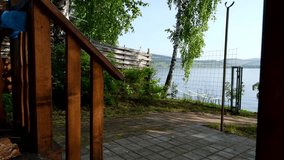 A young woman walking with an inflatable ring in her hand from a house to a lake on a summer morning. Lake view from the first line. The feeling of a calm resort morning, summer vacation and carefree. - Powered by Shutterstock - Get 15% off with code: PIKWIZARD15