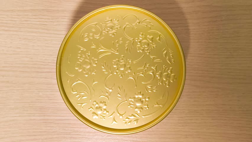 Intricate golden floral pattern rotates on a circular surface, creating a mesmerizing effect, great for luxury packaging, beauty product reveals, or elegant presentation transitions