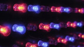 Extreme close-up angled shot of individual RGB LED diodes on a panel, showing red, green, and blue lights flickering in various patterns on a dusty surface, creating a vibrant technology display. - Powered by Shutterstock - Get 15% off with code: PIKWIZARD15