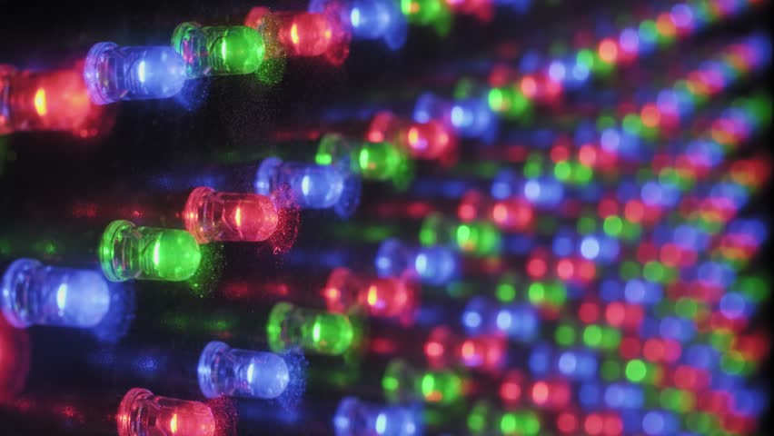 Detailed macro perspective of a pulsing RGB light panel, showing the grid of red, green, and blue diodes flashing in a coordinated rhythm, with visible dust particles on the electronic surface.