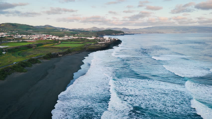 Aerial view of black sand beach with white foam waves Atlantic Ocean. Coast of the island of Azores