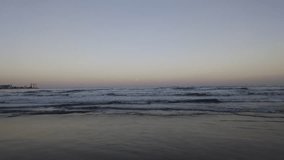 Tranquil evening seascape featuring ocean waves rolling toward the camera under a glowing full moon. Pastel sunset colours reflect softly on the water’s surface, creating a peaceful atmosphere. - Powered by Shutterstock - Get 15% off with code: PIKWIZARD15