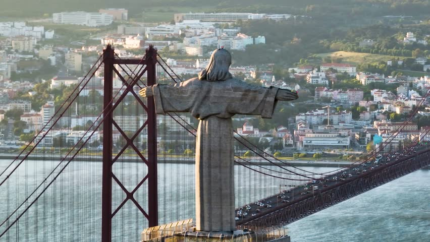 Aerial view of the Cristo Rei statue overlooking the Tagus river and 25 de Abril Bridge, blending the spiritual with the urban landscape, Lisbon, Lisbon, Portugal.