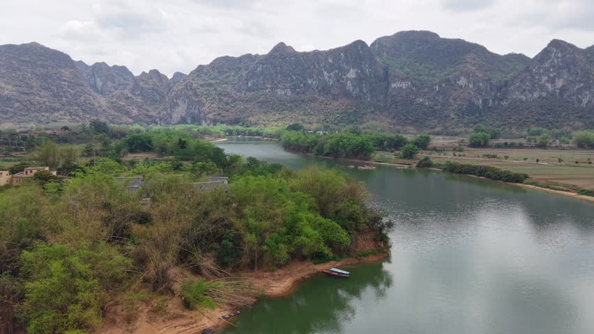 Stunning mountain landscape with rocky hills, green valleys, flowing rivers, and towering trees under a bright summer sky