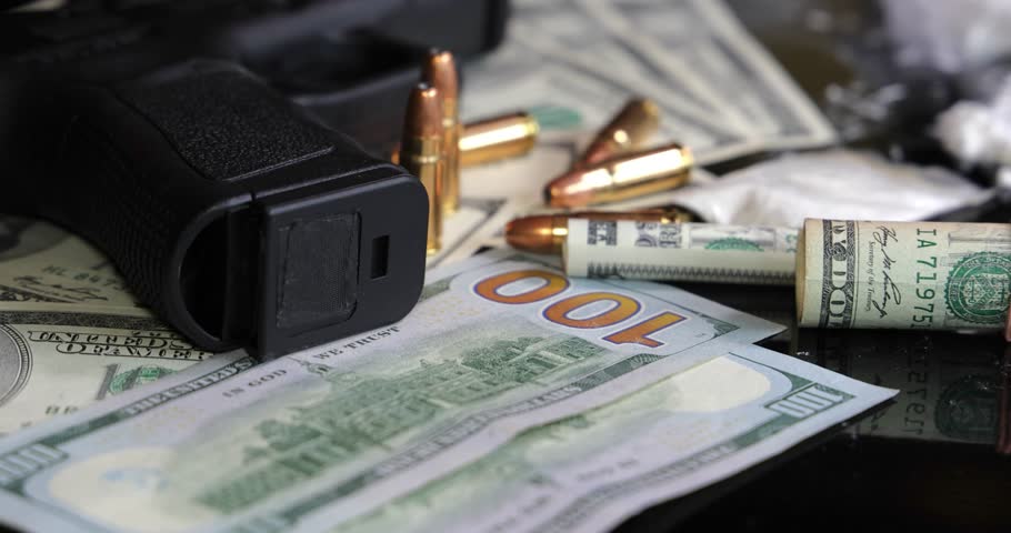 Illegal drugs and cash with gun and bullets on table - crime scene. Gun with bullets lying on the black table. Criminal problems. Drugs and money on black background. Illegal selling
