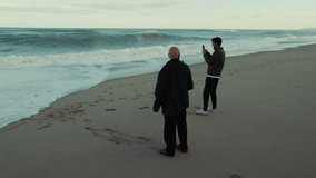Father and Son Watch the Stormy Ocean Waves Crash on the Beach - Powered by Shutterstock - Get 15% off with code: PIKWIZARD15
