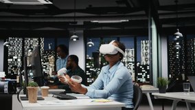 African american woman employs AI gadget with virtual reality in dark office, doing overtime at the corporation workspace with VR glasses to ensure fact checking and analyze projections. Camera A. - Powered by Shutterstock - Get 15% off with code: PIKWIZARD15