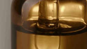 A golden liquid droplet falls into a pool of golden liquid, creating ripples and splashes. The scene is captured in a close-up, abstract, and macro view, emphasizing the fluid dynamics in slow motion. - Powered by Shutterstock - Get 15% off with code: PIKWIZARD15