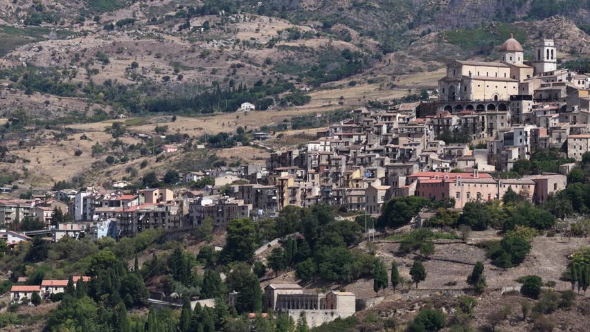 Aerial drone view of Petralia Sottana, a historic Sicilian mountain town surrounded by scenic hills and the Madonie Mountains, featuring traditional stone houses and panoramic landscapes, Sicily Italy