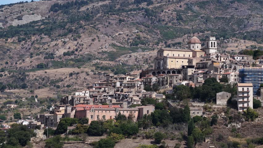 Aerial drone view of Petralia Sottana, a historic Sicilian mountain town surrounded by scenic hills and the Madonie Mountains, featuring traditional stone houses and panoramic landscapes, Sicily Italy