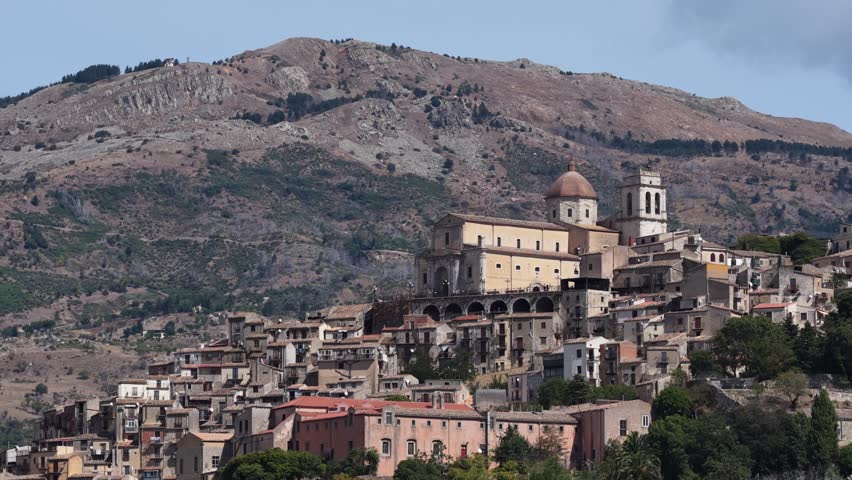 Aerial drone view of Petralia Sottana, a historic Sicilian mountain town surrounded by scenic hills and the Madonie Mountains, featuring traditional stone houses and panoramic landscapes, Sicily Italy