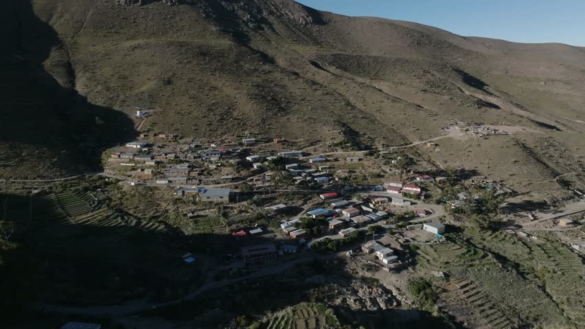 Aerial view of mountain valley with green slopes and sunlight creating shadows