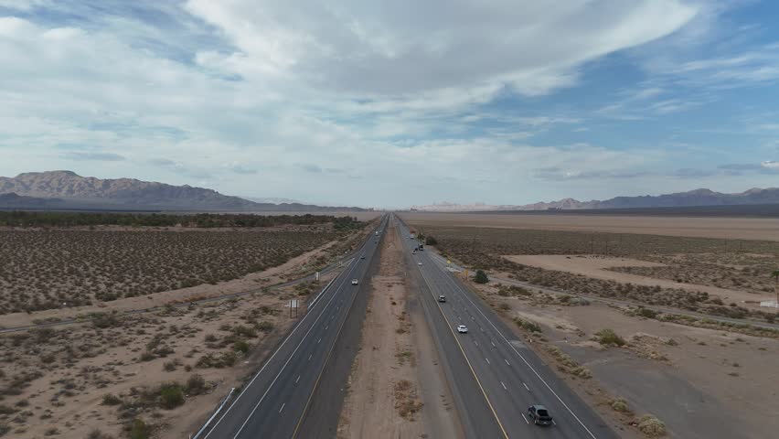 Aerial view on Interstate 15, Barstow Freeway, Nipton California, little traffic on highway, mountains and overcast skies in the distance, Mojave Desert