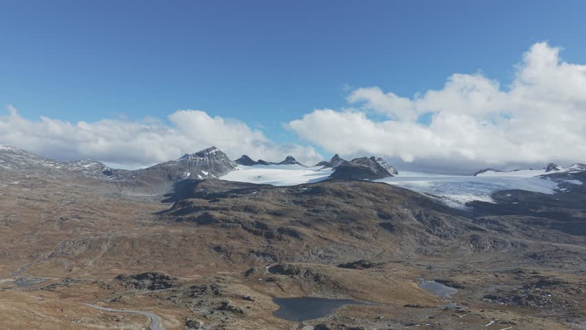 This is a drone video from Jotunheimen National Park, showing glaciers alongside autumn-colored highlands
