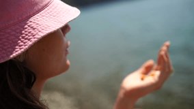 Child beach rocks, girl observes pebble on shore during sunny day. - Powered by Shutterstock - Get 15% off with code: PIKWIZARD15
