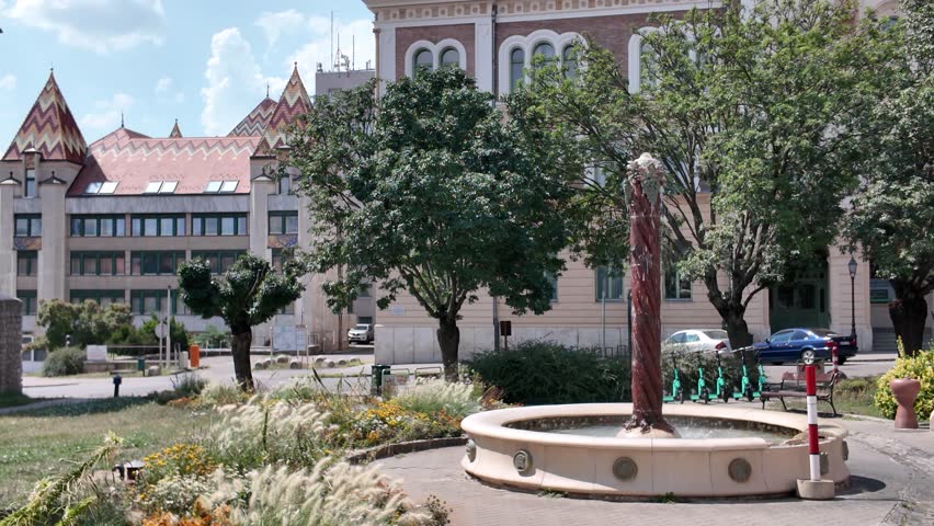 View of Pécs Post Office framed by the Tüke Fountain, blending historic architecture and decorative urban charm