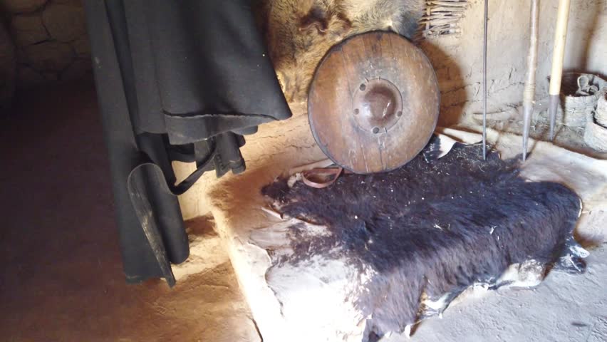 Reconstruction of ancient home with vessels and fireplace.