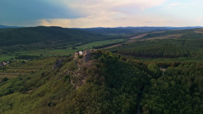 Orbital aerial view around the Castle of Sirok with the spectacular green forests of the Mátra Mountains around in Hungary.