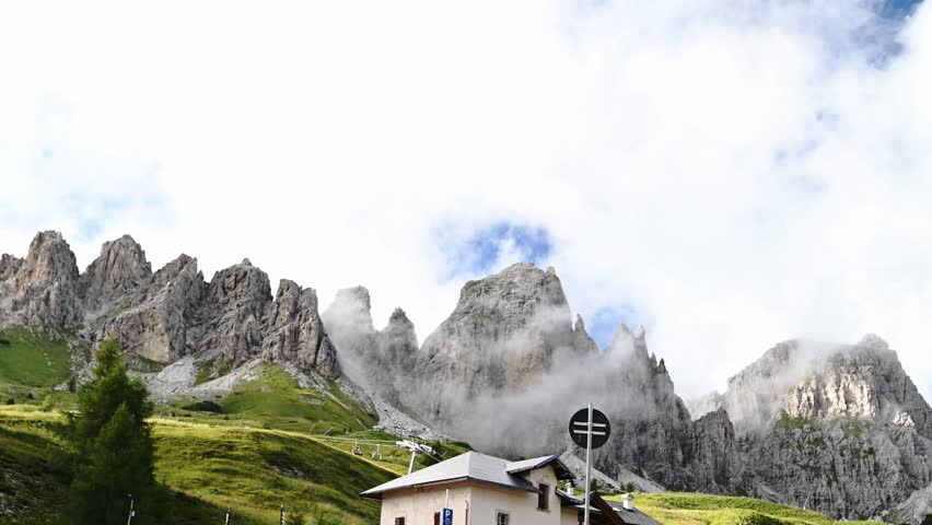Small church and Catinaccio mountains under blue sky in Dolomites