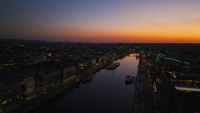 4K cinematic drone footage capturing a golden sunset over Dublin’s Samuel Beckett Bridge with stunning reflections on the River Liffey. Co.Dublin - Ireland_231