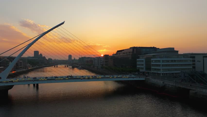 4K cinematic drone footage capturing a golden sunset over Dublin’s Samuel Beckett Bridge with stunning reflections on the River Liffey. Co. Dublin, Ireland_202