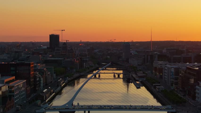 4K cinematic drone footage capturing a golden sunset over Dublin’s Samuel Beckett Bridge with stunning reflections on the River Liffey. Co. Dublin, Ireland_08