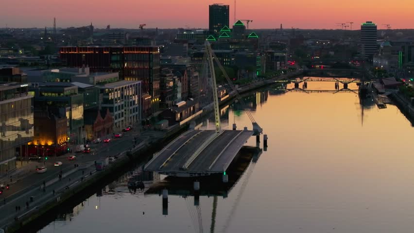 4K cinematic drone footage capturing a golden sunset over Dublin’s Samuel Beckett Bridge during a rare moment when it’s open, with stunning reflections on the River Liffey. Co. Dublin, Ireland_221