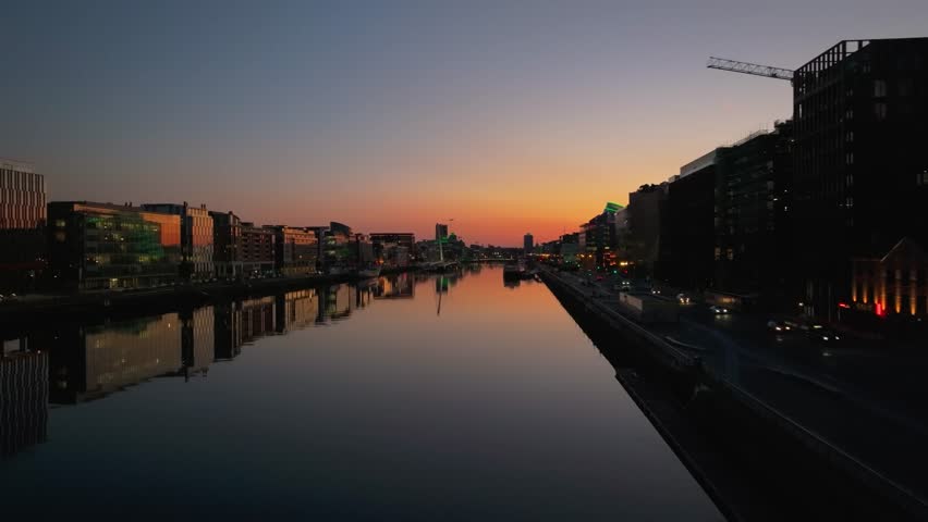 4K cinematic drone footage capturing a golden sunset over Dublin’s Samuel Beckett Bridge with stunning reflections on the River Liffey. Co.Dublin - Ireland_225