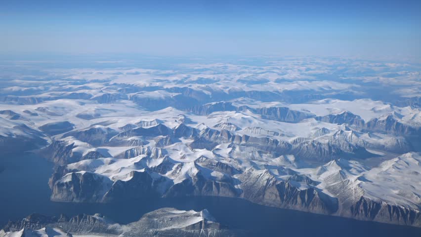 Bright turquoise fjord snakes through snowy mountains on Baffin Island, Nunavut