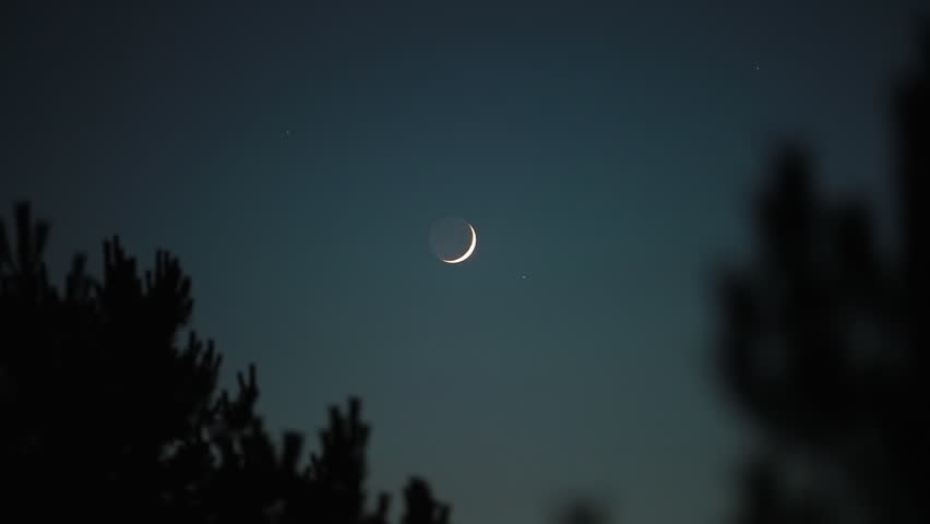 Crescent young Moon with stars, planets and rural countryside tree silhouettes.