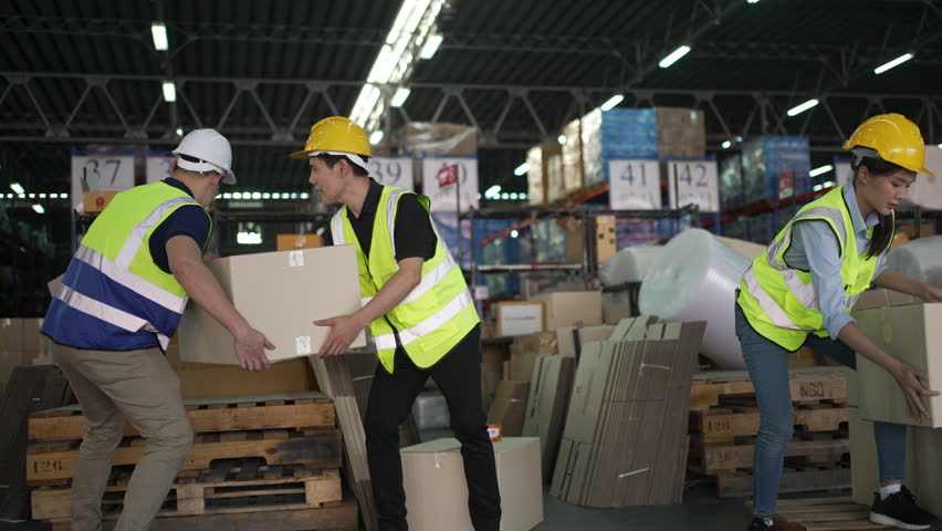 Blue collar workers are working at warehouse. Logistics, transportation.