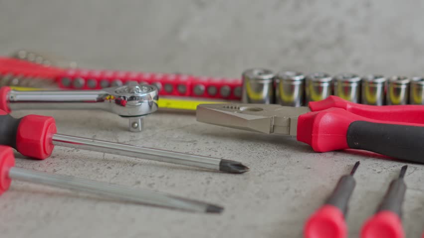 Cinematic view of torque wrench and pliers isolated on textured grey background 