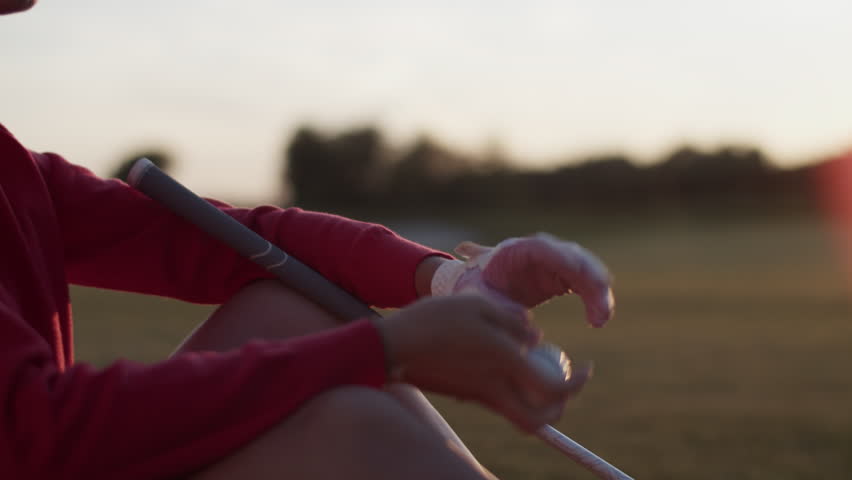 Woman holds golf ball carefully while throwing slightly in air