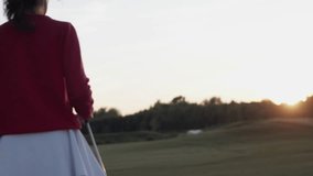 Woman golfer walks on golf course holding golf club after game - Powered by Shutterstock - Get 15% off with code: PIKWIZARD15