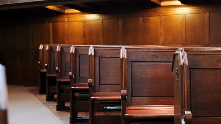Empty, wooden church pews or benches inside protestant church. Wide angle, panning shot, real time, no people
