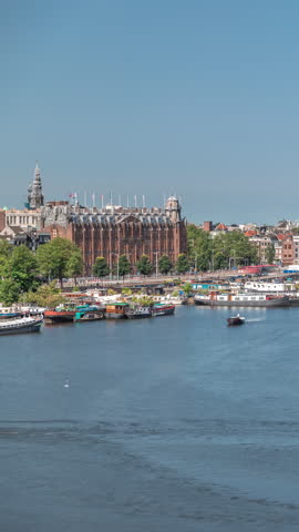 Aerial panorama of a Chinese restaurant in the form of pagoda on the water, set against the backdrop of historical city center buildings and floating boats on a river timelapse. Amsterdam, Netherlands