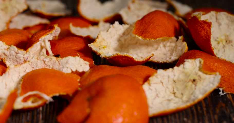 peeled oranges on the table, a large amount of peel of peeled citrus fruits on the table