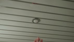 Close-up hand of unrecognizable man replacing lightbulb in ceiling fixture, performing home improvement and maintenance tasks, ensuring proper lighting function in bathroom. Shooting in slow motion. - Powered by Shutterstock - Get 15% off with code: PIKWIZARD15