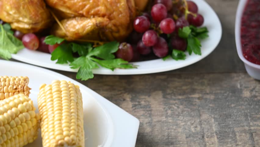 Thanksgiving dinner on rustic wooden table with roasted turkey,mashed potatoes,ears of corn and green bean casserole	