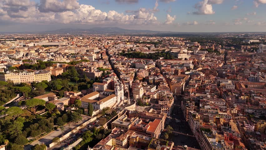 Aerial drone panoramic view of Rome with iconic rooftops, terracotta tiles, domes, and historic architecture under sunny sky, capturing timeless Italian cityscape charm