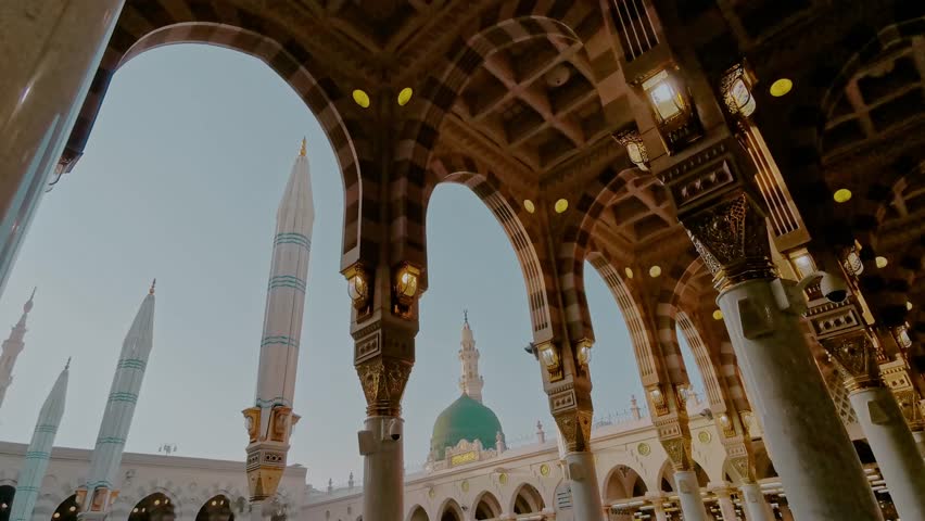 Static closeup view green dome and Moorish pattern arches of Nabawi mosque in Al Madinah, Saudi Arabia. 