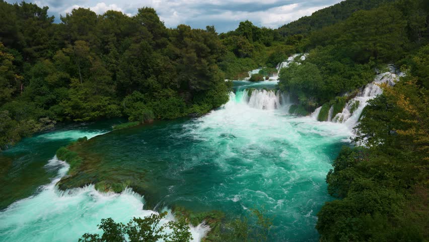 Waterfalls and clear blue river running through lush forest at Krka National Park in spring, Croatia