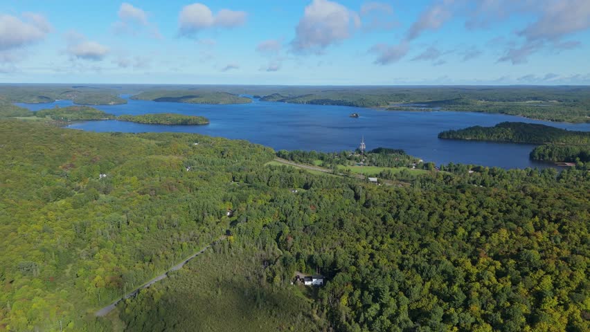 Aerial Flyover Of Pristine Forest And Telecommunications Tower By Lake Vernon At Huntsville, Muskoka.