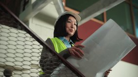 Korean Chinese business woman holding blueprint smiling businesswoman Japanese Asian female building construction plan project satisfied builder happy girl architect boss civil engineer in hard hat - Powered by Shutterstock - Get 15% off with code: PIKWIZARD15