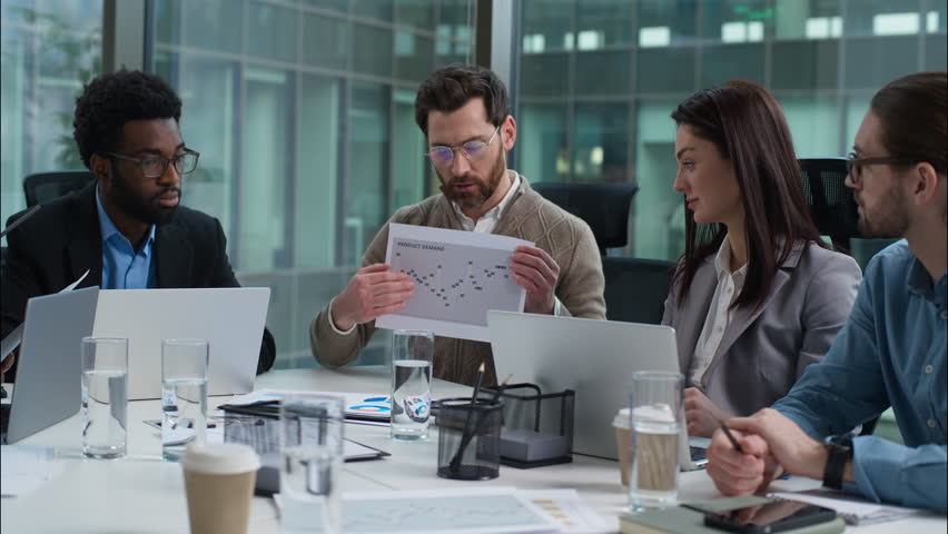 Caucasian leader analysis data graph report talking speaker statistics paper document multiracial colleagues business team diverse businesswomen businessmen meeting strategy plan presentation office - Powered by Shutterstock - Get 15% off with code: PIKWIZARD15